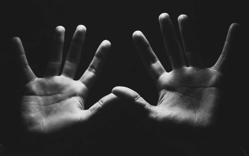indoors, shadow, human limb, darkness, stop gesture, finger, body part, human finger, human body part, dark, palm, aggression, human hand, sadness, black background