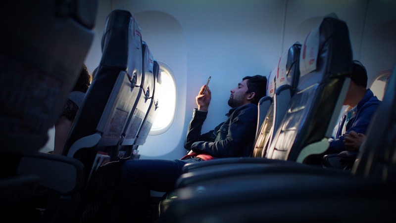 one man only, phone, airplane, transportation, men, person, car, males, seat, anxiety, inside, phone in, only men, wearing, people, waiting, black, vehicle interior
