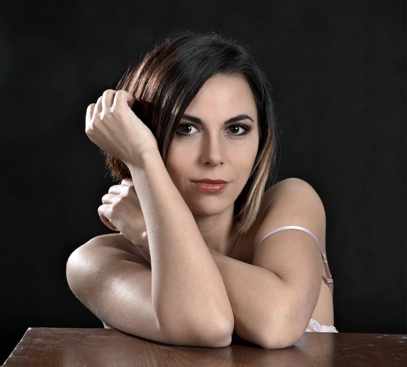 headshot, contemplation, hairstyle, looking at camera, head in hands, fashion, one person, wearing, top, table, beautiful woman, on the basis of, woman