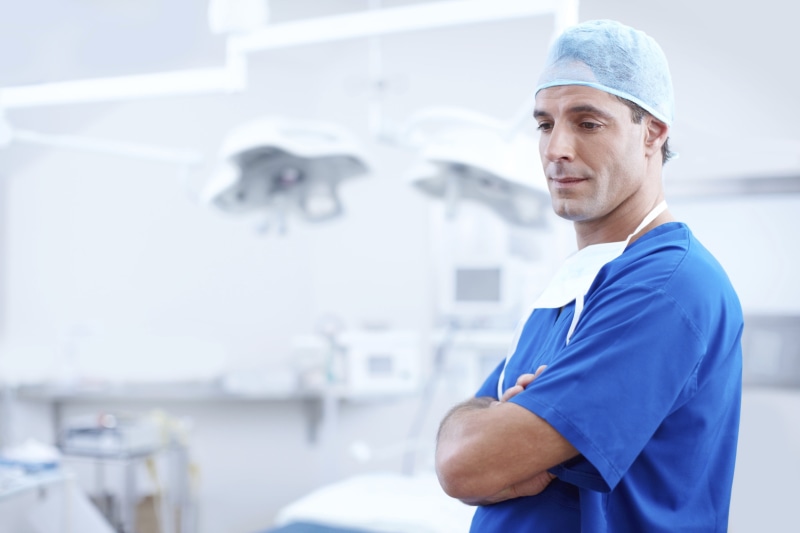 looking at camera, one man only, male, medical, focus on foreground, operating room, healthcare, man, doctor, adults only, one person, specialist, uniform