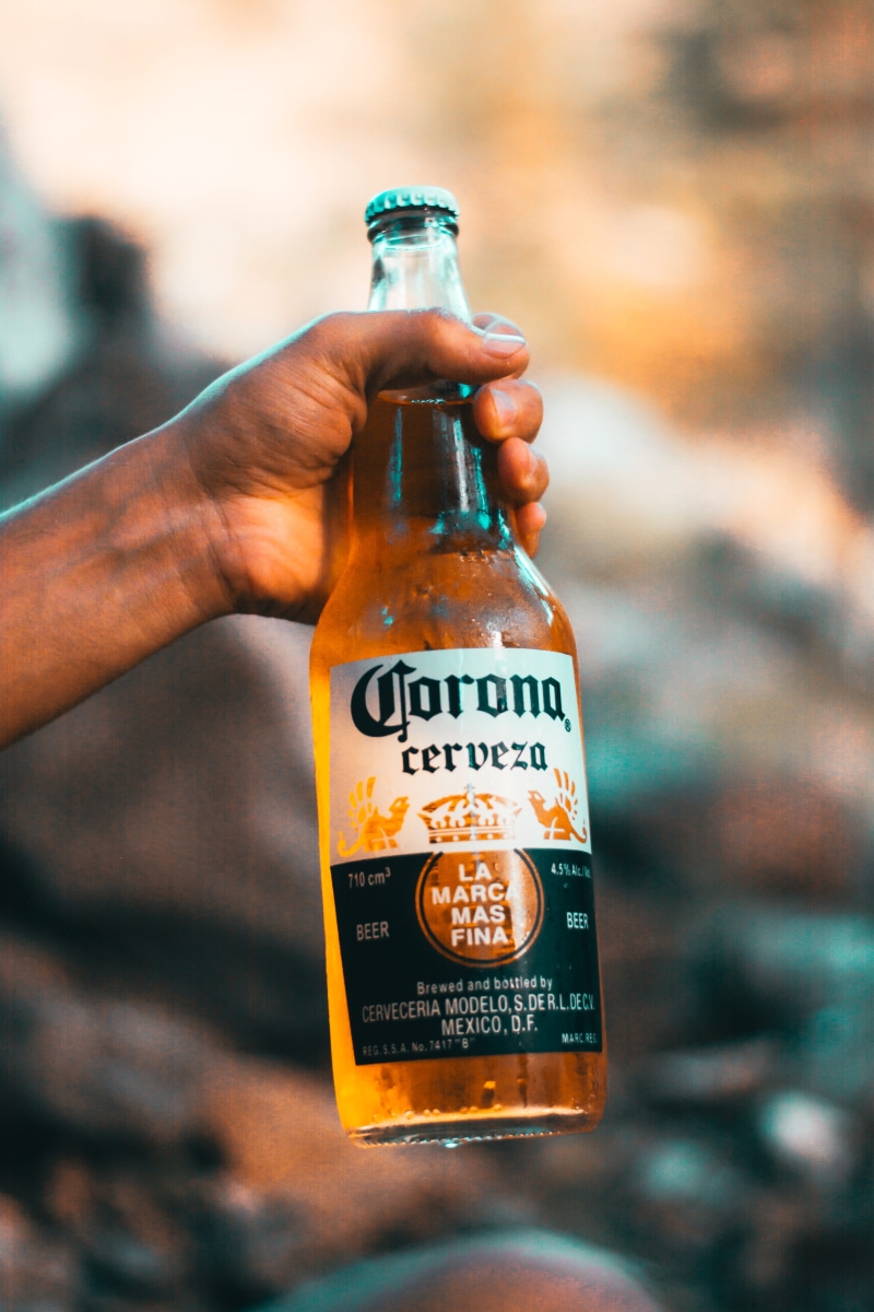 food and drink, hand, human body part, beer, person, close-up, selective focus, communication, alcoholic beverage, text, blurred background, human hand
