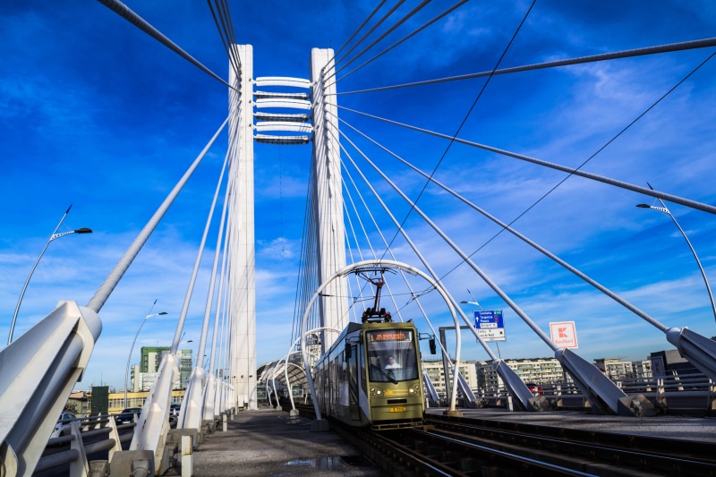 sky, travel, skyscraper, cable, city, track, building, road, built structure, bridge, steel, building exterior, suspension bridge, blue, train, rail transportation