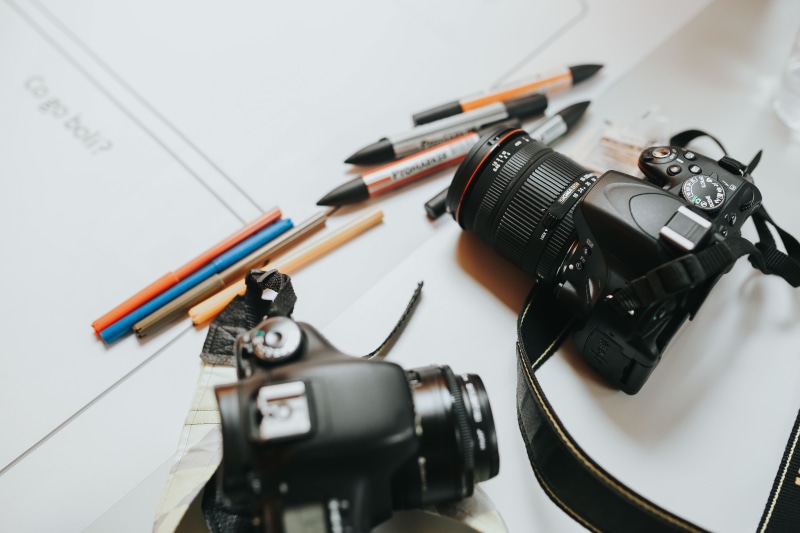 photographic equipment, high angle view, people, ideas, design, communication, technology, work, digital camera, table, project, photography themes, writing instrument