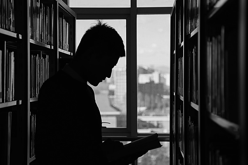 panes, standing, waist up, side view, shelf, window, book, black and white, 2K, people, indoors, reading, silhouette, read, day, one person, near, real people