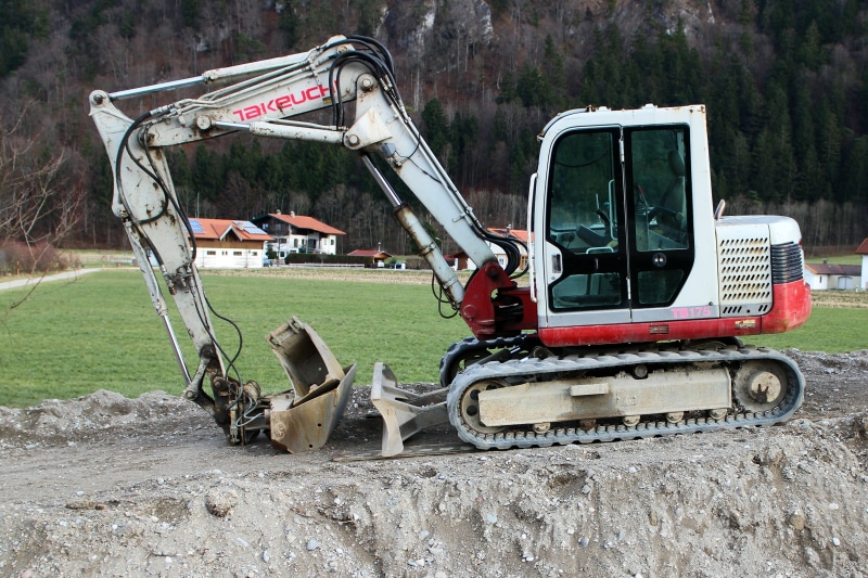 excavator buckets, mode of transportation, land vehicle, outdoors, nature, construction site, field, red, grass, truck, near, construction machinery, white