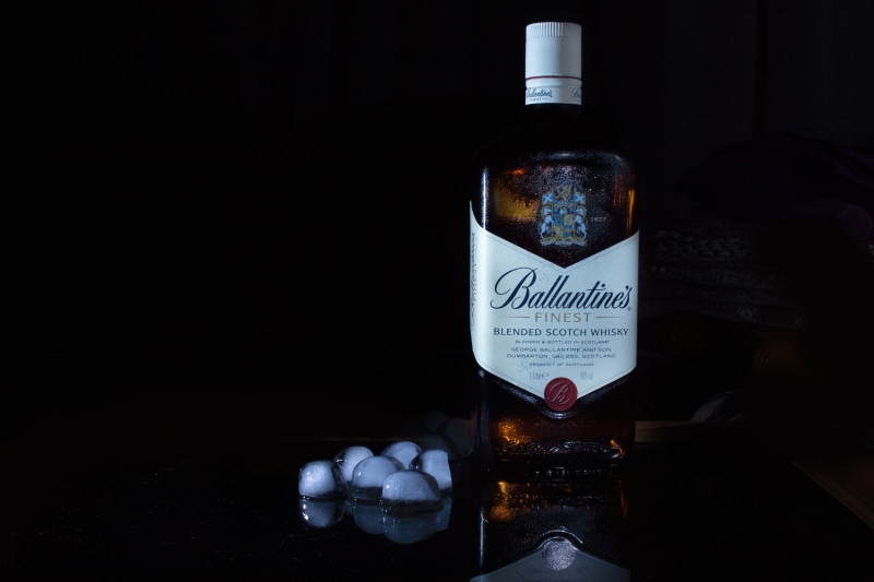 black background, product shot, glass, sphere, product, alcohol, water, text, ballentine, label, copy space, indoors, 5K, beverage, ice, liquor, cocktail