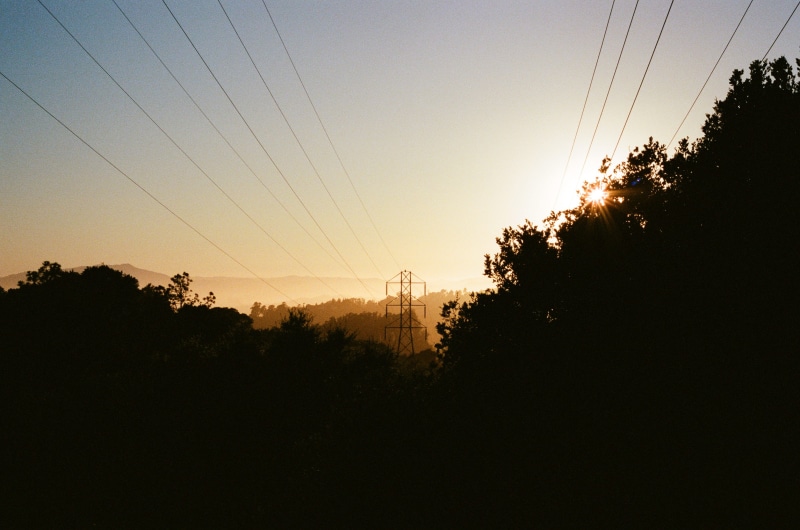 2K, power supply, beauty in nature, sky, sunset, power line, hills, no people, light, utility pole, outdoors, tranquility, dusk, flare, electric transmission tower