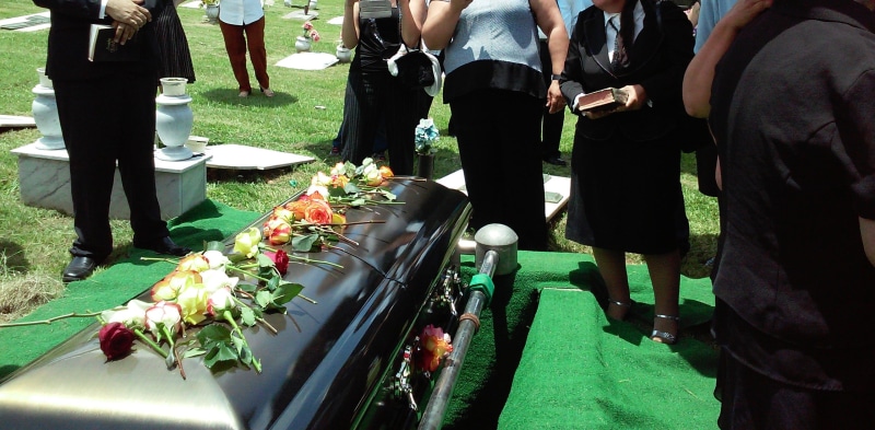 flower arrangement, medium group of people, real people, surrounded, burial, plant, day, low section, flowering plant, flower, group, grass, people, standing