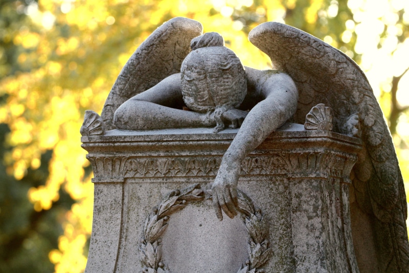 memorial, concrete, spirituality, symbol, outdoors, sadness, day, park, focus on foreground, human representation, stone Material, plant, grief, nature