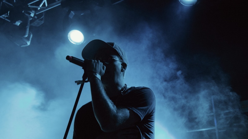 one person, man, stage, smoke - physical structure, enjoyment, singer, dark, performance, stage - performance space, event, plucking an instrument, illuminated