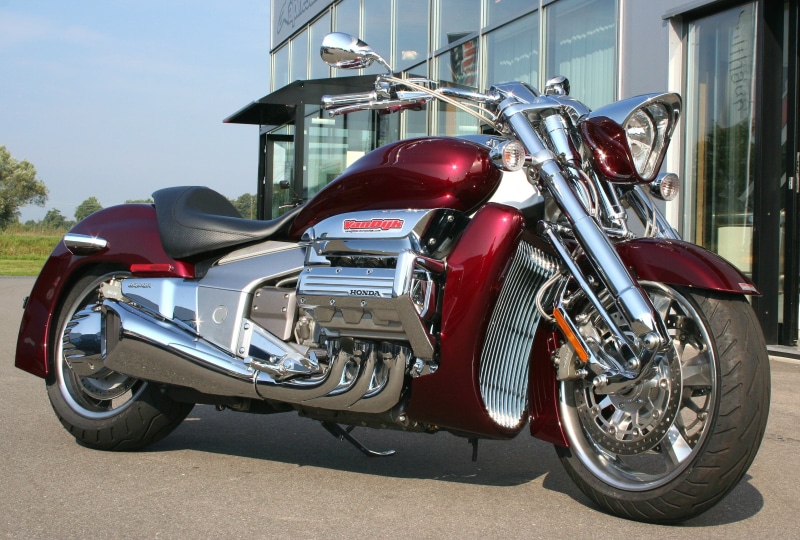 built structure, street, day, sky, red, chrome, transportation, cruiser, motorcycle, scooter, road, stationary, no people, show vehicle, nature, luxury