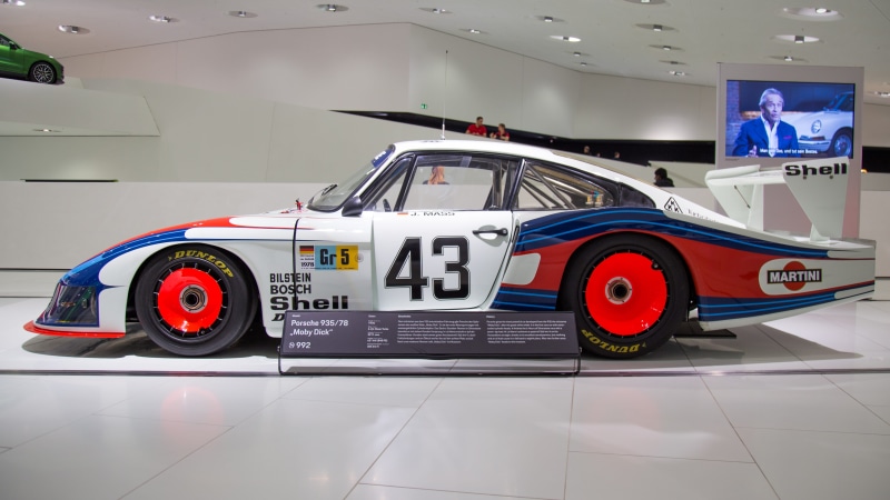 transportation, white, display, indoors, competition, car show, car, mode of transportation, number, motorsport, professional sport, person, pit stop, car wheel