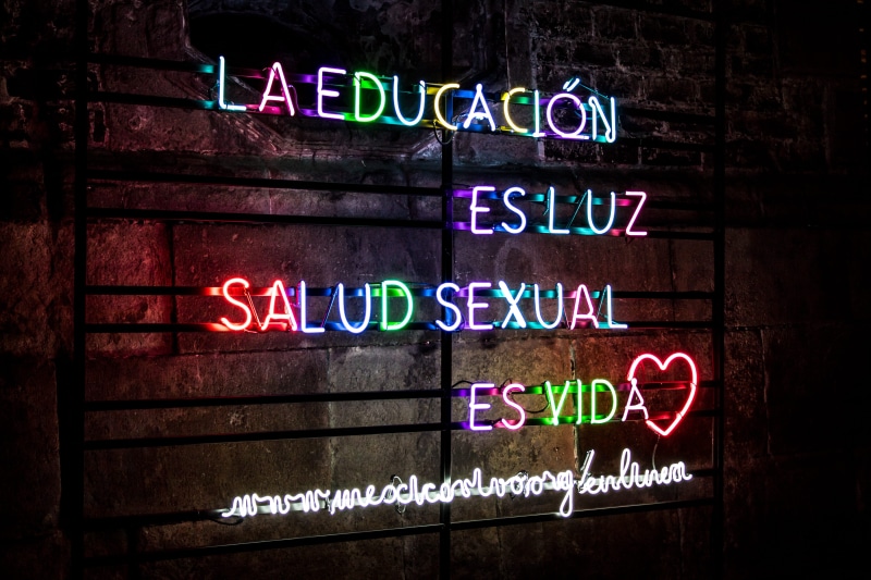 neon lights, neon, no people, western script, sign, electric light, spanish, communication, brick wall, quote, design, built structure, glowing, signage