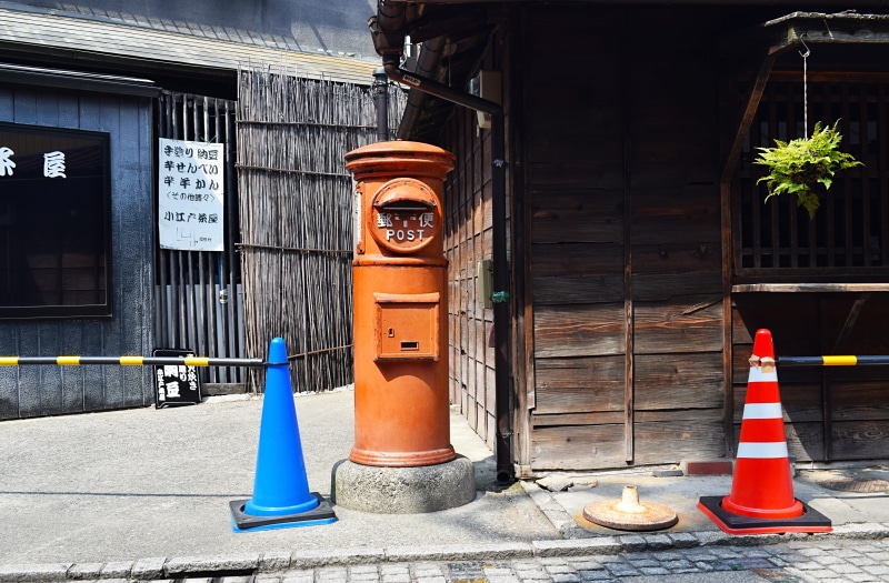 furniture, day, postbox, road, street, concrete, traffic cone, cone, kiosk, two, banister, fire hydrant, sign, communication, built structure, town, urban
