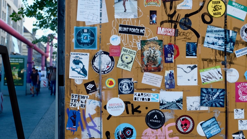 western script, surface, sign, sticker, poster, steel, stickers, creativity, notice, wall, label, representation, communication, wall - building feature
