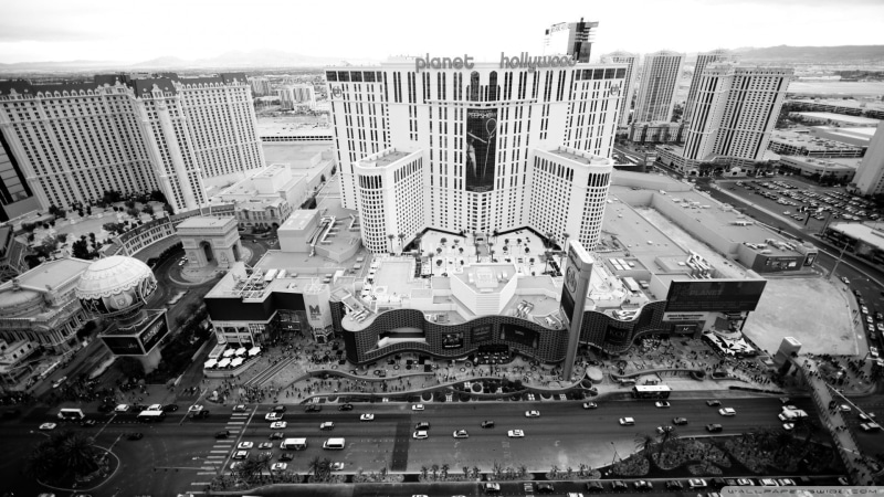 incidental people, skyscraper, architecture, high angle view, day, building exterior, built structure, motor vehicle, monochrome, crowd, outdoors, mode of transportation