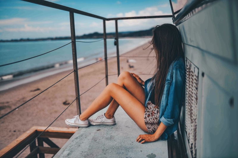 woman, railing, gray, teenager, women, brunette, contemplation, sitting, metal, skirt, casual clothing, full length, legs, model, floor, real people, staring