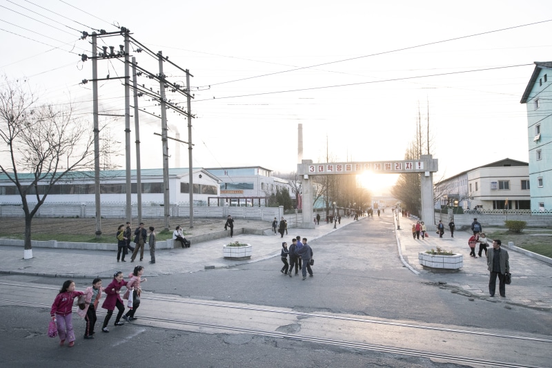 architecture, people, electricity, road, near, street scene, transportation, sky, pyongyang, tarmac, path, land vehicle, standing, human, streets, outdoors