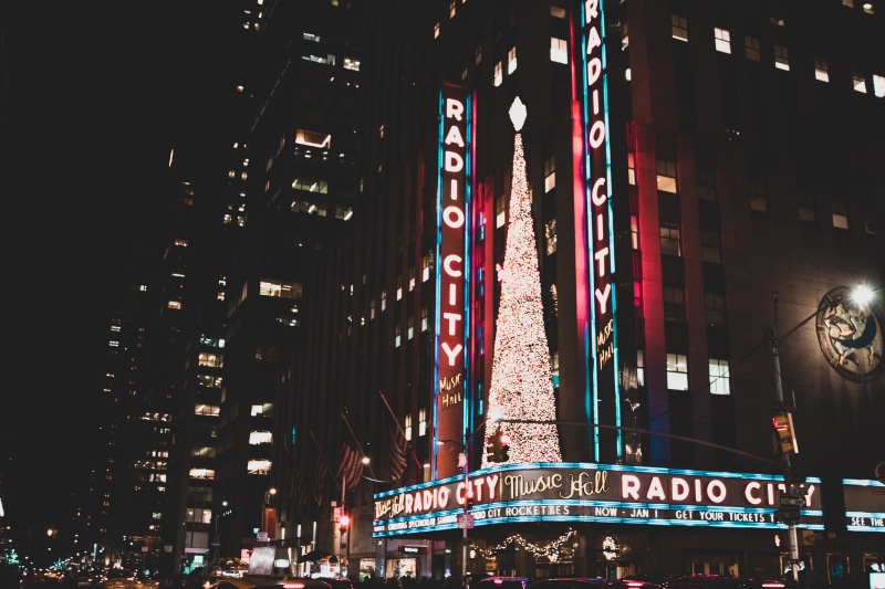 new york city, travel destinations, music hall, sign, built structure, night photography, building, manhattan, night, radio city, illuminated, architecture