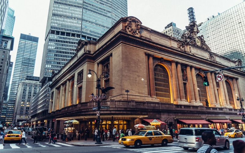 transportation, statue, New York City, traffic, pedestrian, skyscraper, Grand Central Station, land vehicle, American flag, building exterior, yellow taxi