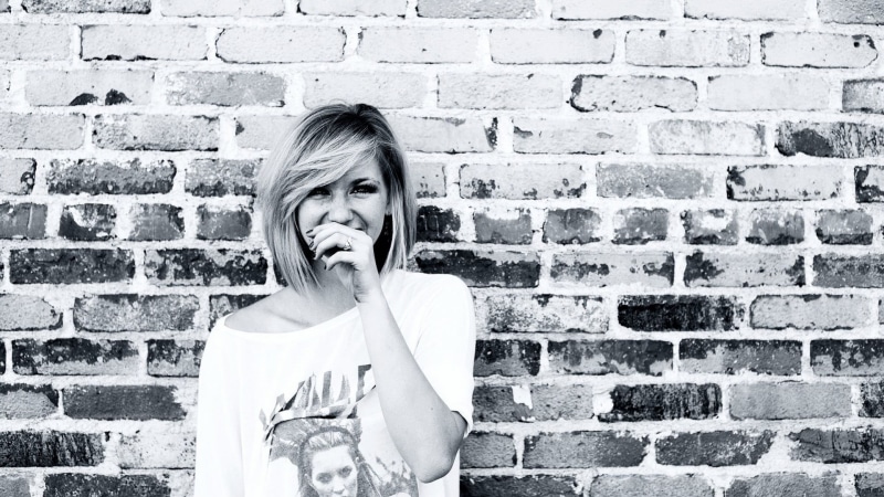 brick, front view, young adult, one person, blonde, young women, built structure, brick wall, hairstyle, emotion, making a face, Ellie Goulding, looking at camera