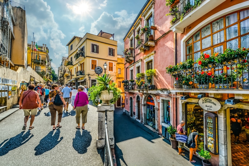 leisure activity, sunlight, travel, built structure, shopping, building exterior, town, lifestyles, italy, sunny, outdoors, architecture, adult, picturesque
