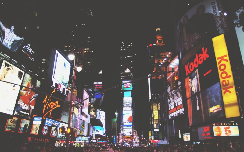 commercial sign, building exterior, text, city life, advertisement, incidental people, cityscape, New York City, building, street, modern, skyscraper, illuminated