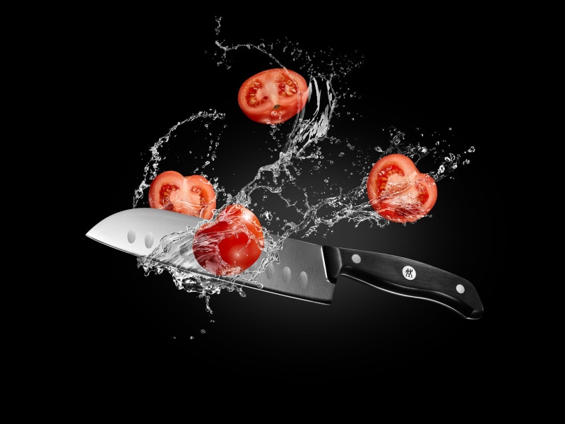 food, fruit, black background, splashing, knife, advertisements, food and drink, exploding, red, aggression, no people, tomatoes, motion, studio shot, water