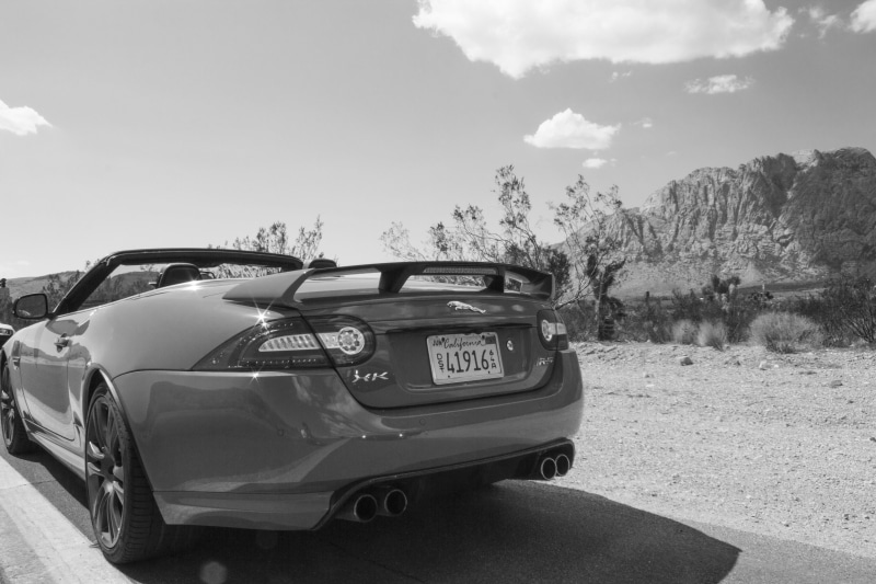 Jaguar (car), road trip, city, vehicle, monochrome, sky, sunlight, cloud - sky, outdoors, on the move, road, transportation, sports car, black, retro styled