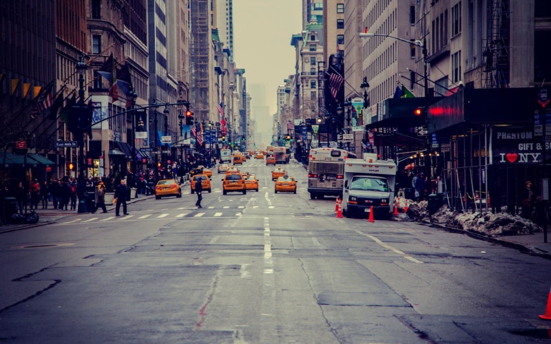 building exterior, land vehicle, building, yellow, cars, traffic, built structure, motor vehicle, car, city, direction, street, taxi, road, city street
