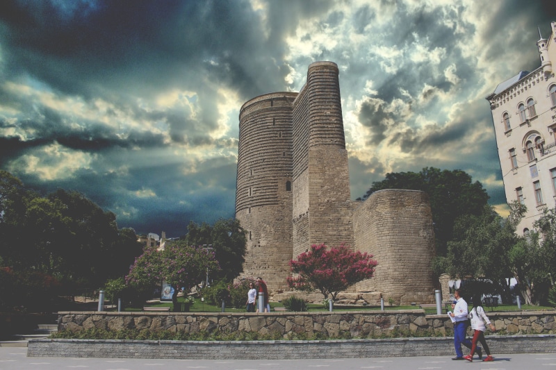 architecture, maiden tower, office building exterior, skyscraper, built structure, cloud - sky, city, real people, plant, people, outdoors, sky, landmark