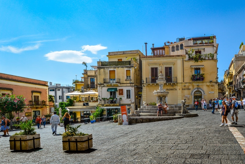fountain, urban Scene, old, women, cityscape, sky, men, residential district, building Exterior, nature, 2K, Town, crowd, town Square, italian, house