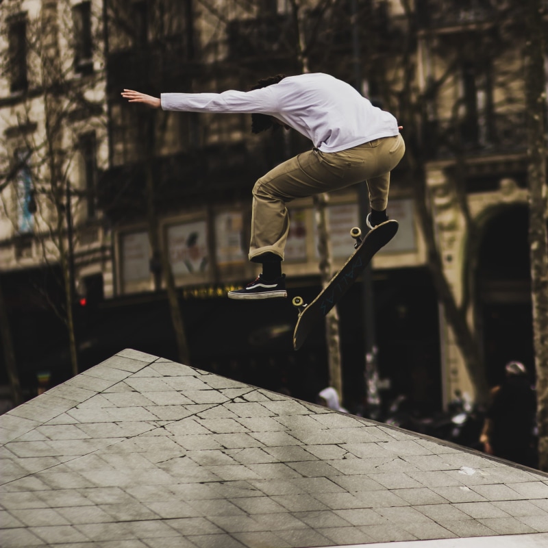 recreation, mid-air, focus on foreground, skater, building exterior, jumping, day, jump, human arm, skate park, playing, full length, skateboarding, person