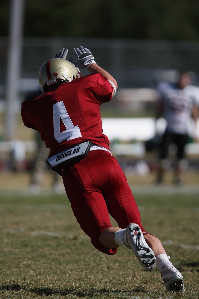 athleticism, athlete, kick blocker, teenager, extended, grass, activity, game, determination, child, sports equipment, incidental people, athletic, sports helmet