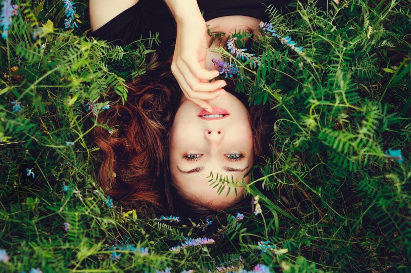 1080P, field, black clothing, real people, nature, green color, flowers, hairstyle, day, lying down, hazel eyes, land, beautiful woman, women, lying on back
