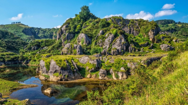 solid, sky, non-urban scene, mountain, beauty in nature, plants, growth, tree, clouds, lake, no people, scenics - nature, rock, outdoors, rock formation