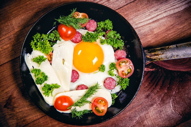 preparing food, egg yolk, table, herb, cheese, freshness, frying pan, fruit, eggs, kitchen utensil, directly above, vegetable, food and drink, high angle view