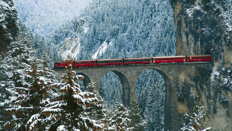 cliff, public transportation, snowing, train, plant, mountain pass, snow, bridge, nature, pine trees, cold temperature, architecture, bridge - man made structure