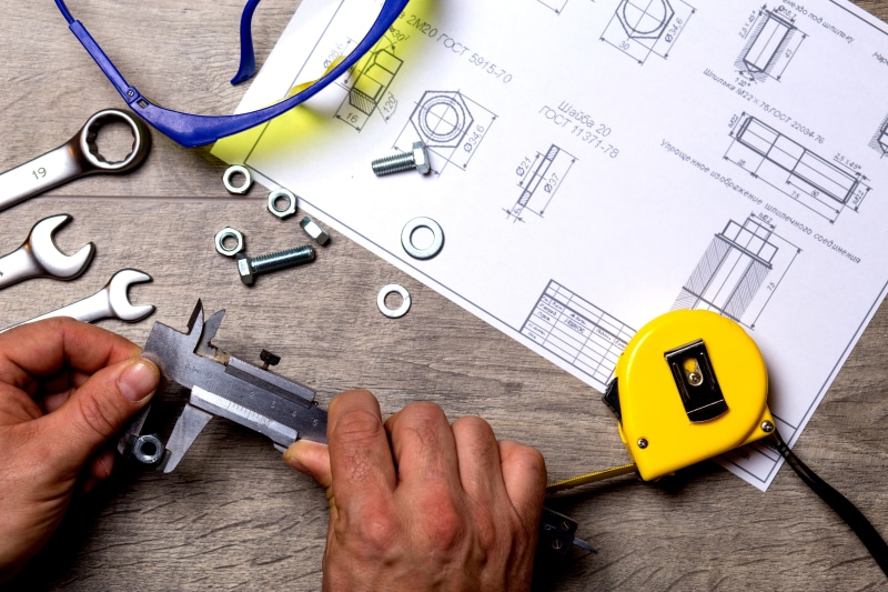 holding, body part, adult, black, equipment, paper, tool, hands, front, sketch, 5K, metal, roulette, wrench, repair, human hand, working, table, measurement