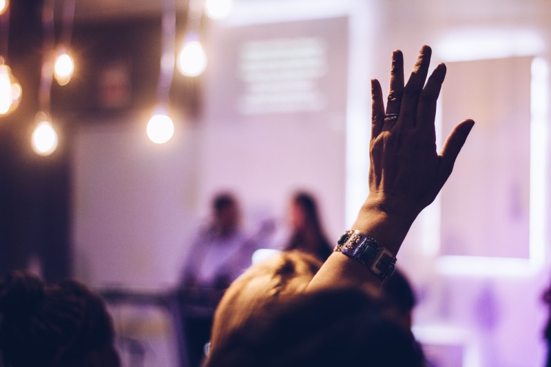 indoors, enjoyment, audience, illuminated, defocused, finger, focus, men, rase hand, hand up, raising, spectator, crowd, large Group Of People, raised had