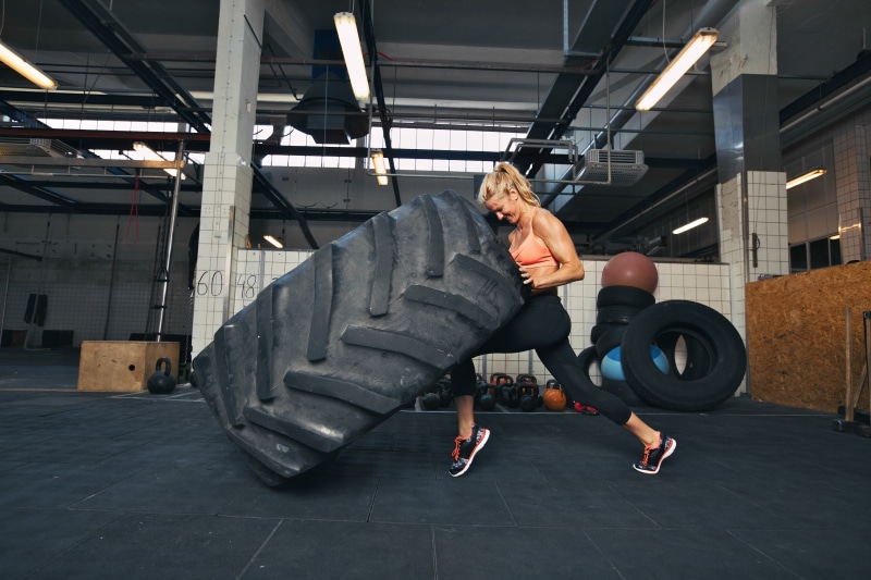 flooring, sport, tire, effort, indoors, crossfit, men, 5K, one person, built structure, young men, lifestyles, full length, strength, casual clothing