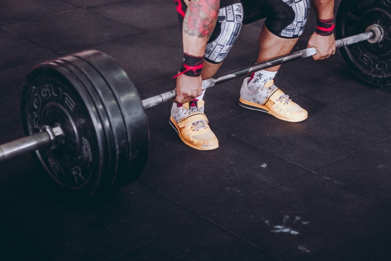 human foot, gray, footwear, sports equipment, tire, bodybuilding, low section, man, barbell, gym, guy, strength, human leg, heavy, athlete, shoe, bodybuilder
