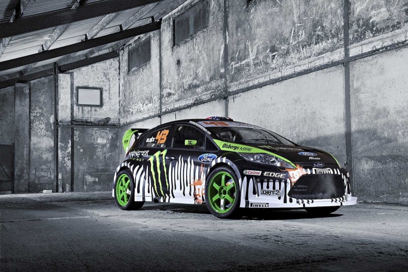 rally cars, transportation, graffiti, wall, concrete, garage, isolated color, no people, car, land vehicle, day, stationary, outdoors, art and craft, motor vehicle
