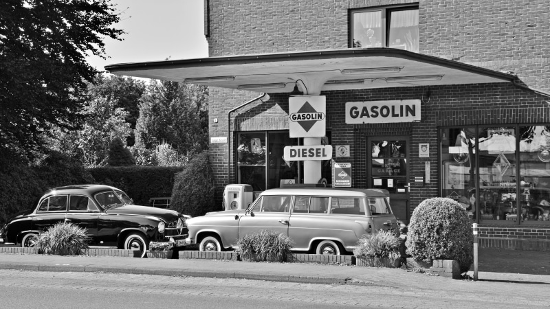 transportation, outdoors, historically, sign, text, traffic, building exterior, city, road, nature, car, mode of transportation, western script, refuel