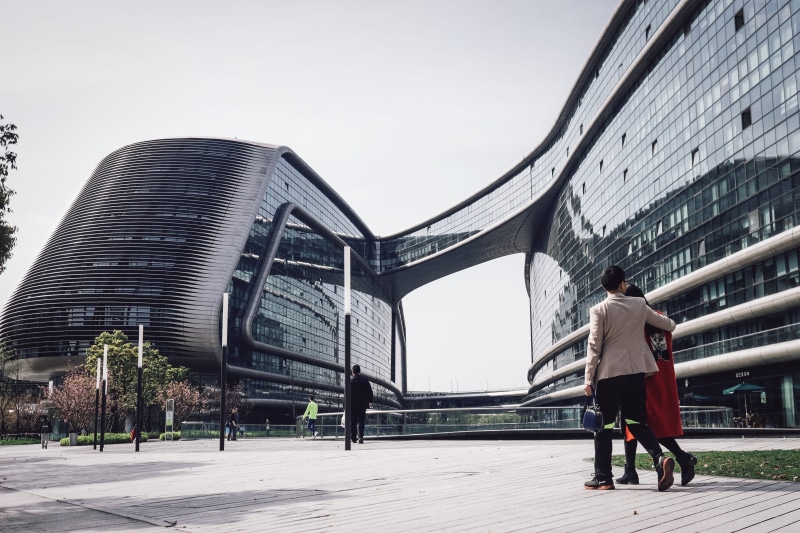 walking, incidental people, men, bridge, adult, jacket, great modern building, building, one person, windows, woman, suit, zaha hadid, rear view, bridge - man made structure
