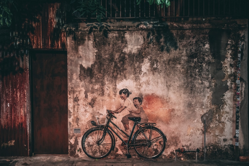 painting, day, art, bike, land vehicle, wall art, building exterior, built structure, run-down, weathered, urban, mode of transportation, cyclist, graffiti