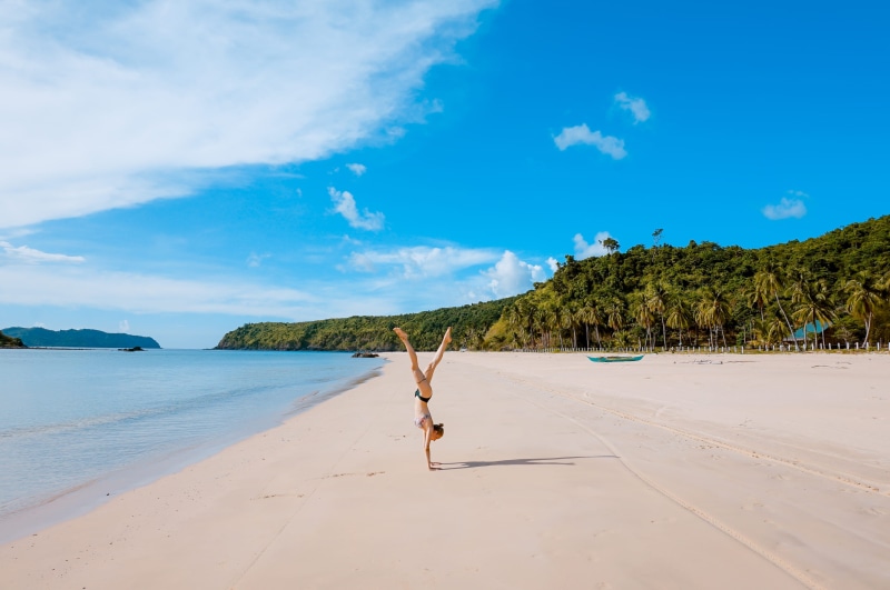 lifestyles, cumulus, arms raised, brown, nature, handstand, palawan, outdoors, full length, sky, tree, seaside, beauty in nature, ocean, real people, sea