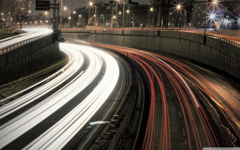 traffic, high angle view, motion, multiple lane highway, no people, speed, vehicle light, street light, light trail, light trails, building exterior, blurred motion