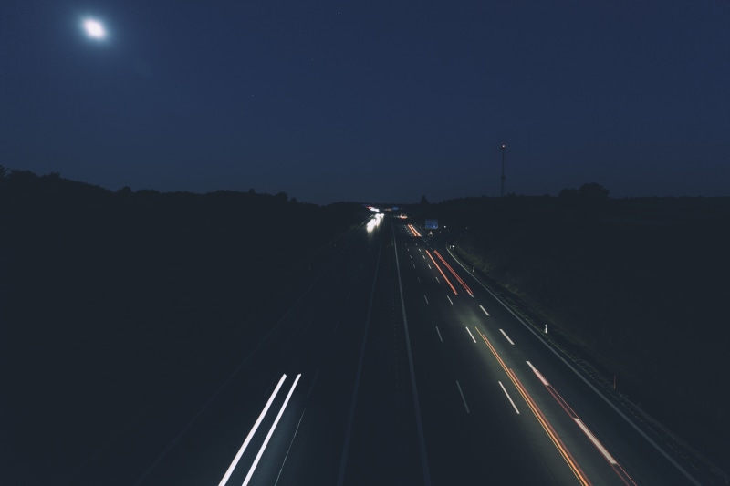 no people, mode of transportation, fan, light trail, multiple lane highway, night, illuminated, highway, speed, white, street, nature, direction, long exposure