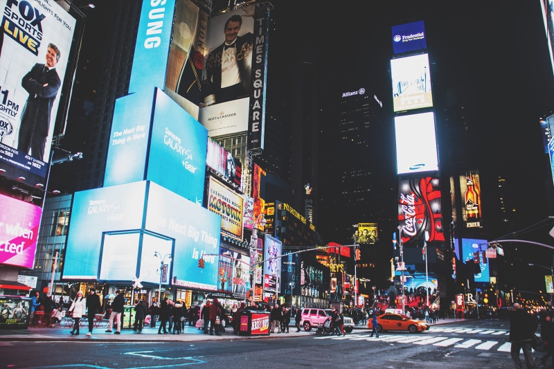 group of people, built structure, lights, city street, night time, car, city life, mode of transportation, outdoors, night, crowd, buildings, traffic, skyscraper